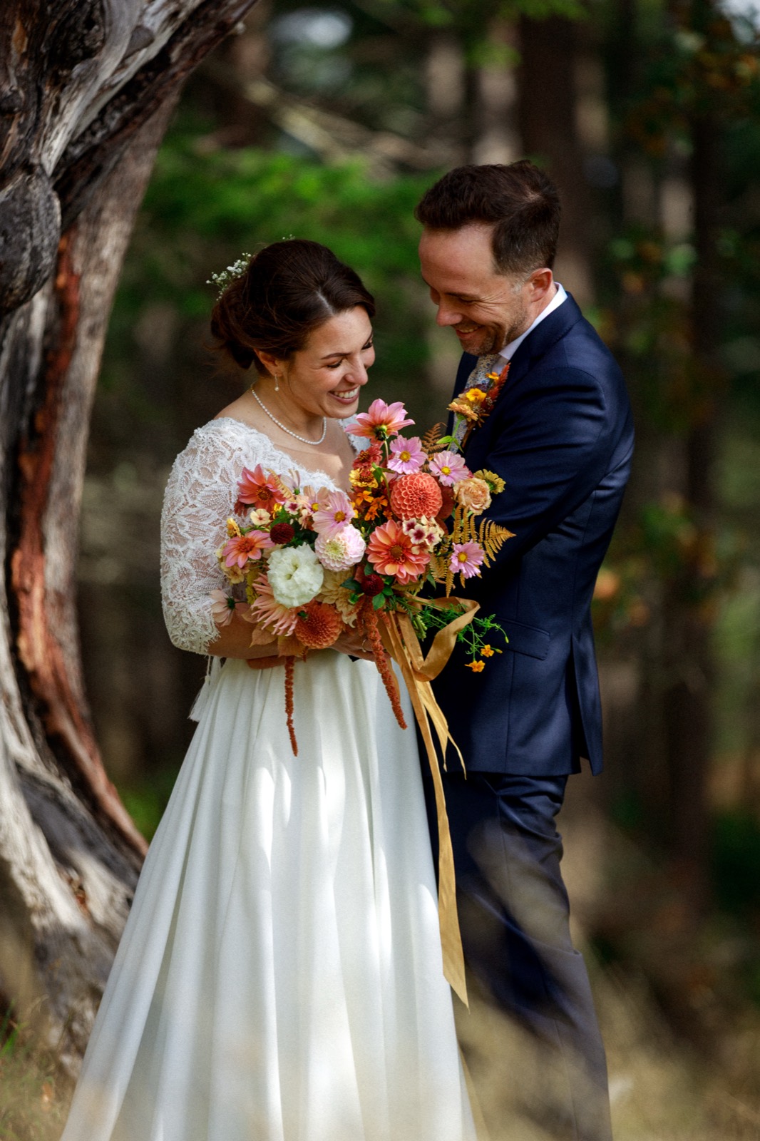 A couple holding an autumn bouquet in woodland