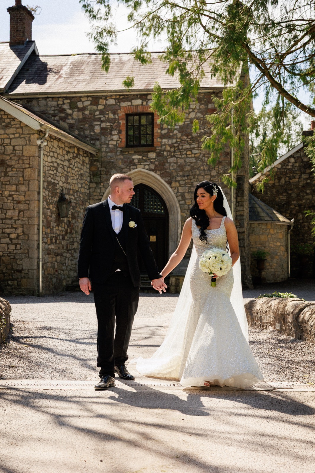 A couple walking hand in hand at a stone venue