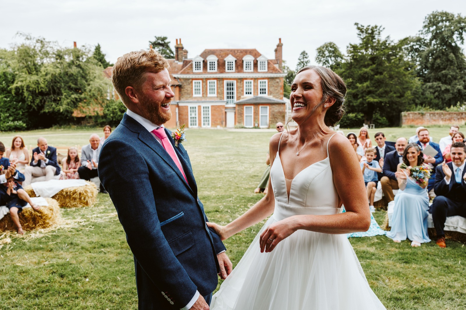 Guests laughing during an outdoor wedding ceremony in South Wales