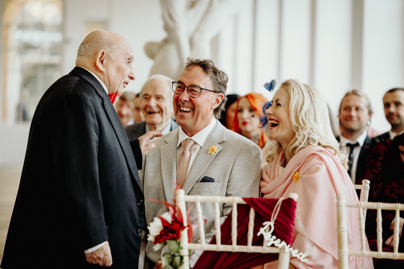 Guests in the front row laughing during the ceremony